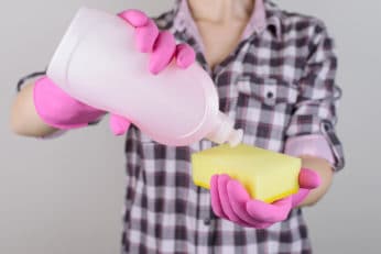 a person pouring soap on a sponge