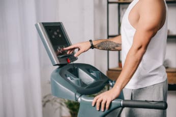 man pushing buttons on the control panel to start jogging