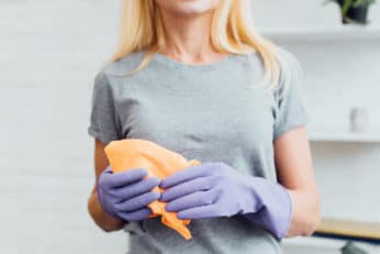 woman using a cloth to wipe down her kitchen appliance