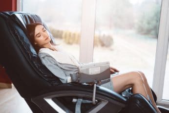 young woman relaxing on a massage recliner