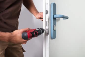 carpenter installing a door lock