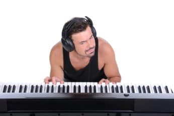 a man playing the piano with a headphone