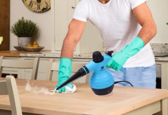 a man steam cleaning a wooden table
