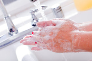 Woman Washing Hands in the Kitchen Sink.