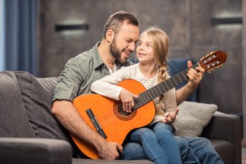 father and daughter playing a musical instrument