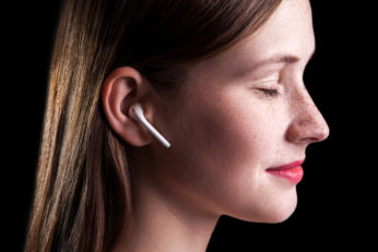 young woman wearing white in-ear headphones