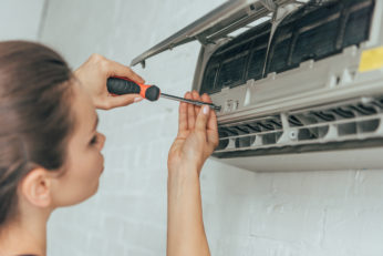 young woman repairing air conditioner